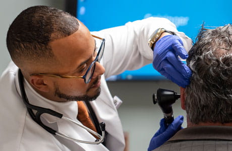 Doctor looking into a mans ear.