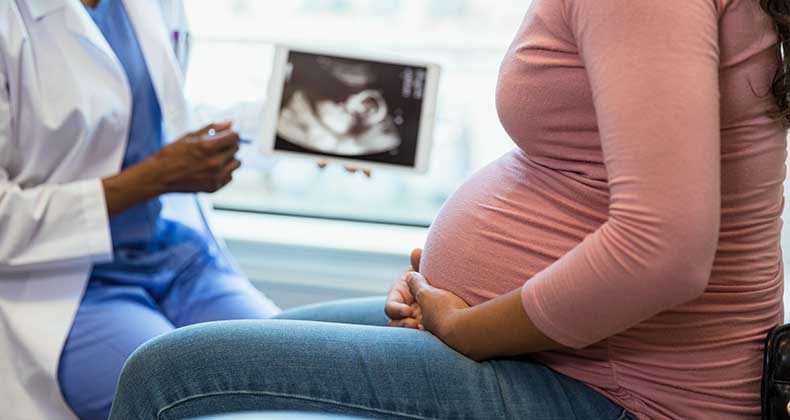A pregnant woman talking to her doctor