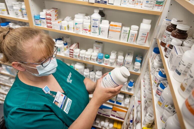 Pharmacist inspecting a medication bottle